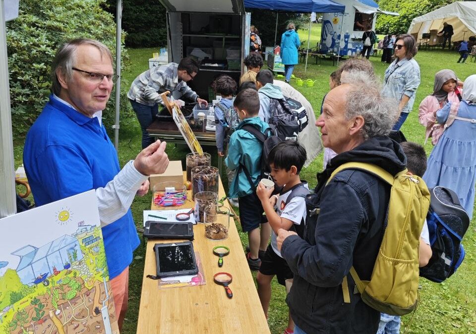 Kinder entdecken Bodenlebewesen am Umweltbildungsstand von Ackerperlen beim Kindertag des Rotary Clubs im Tierpark Hagenbeck.