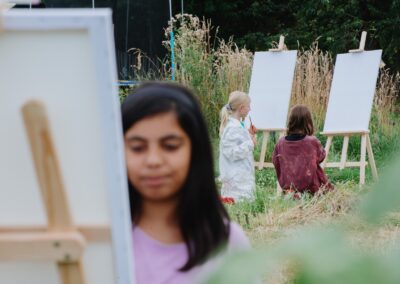 Kinder gestalten Naturbilder an Staffeleien beim Umweltbildungsprogramm von Ackerperlen