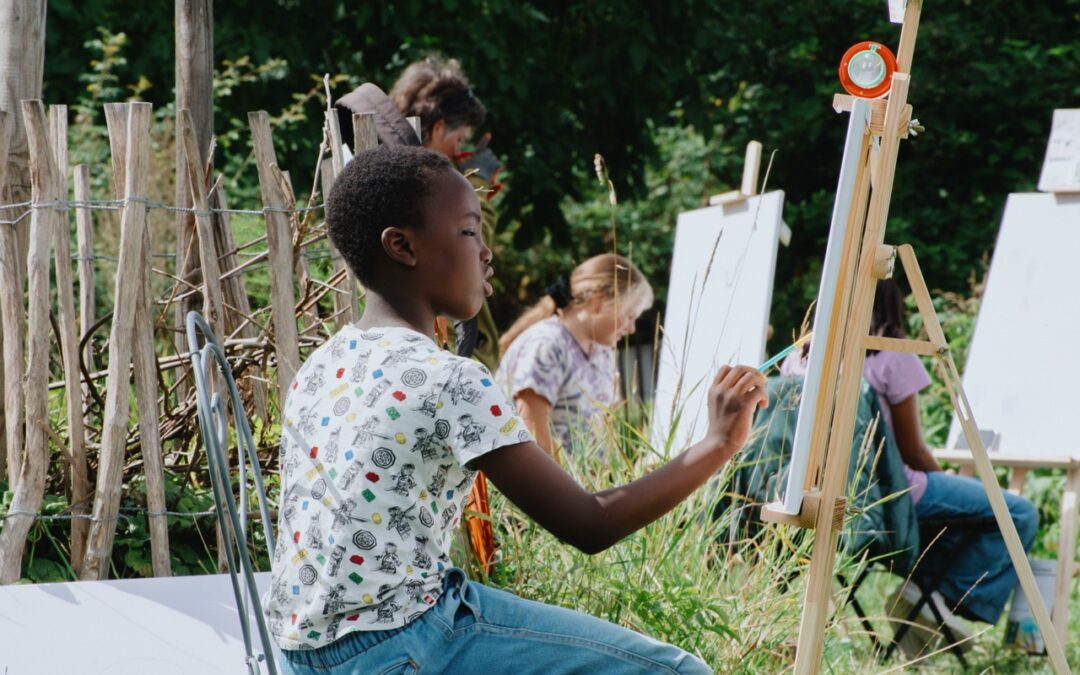 Kind malt an einer Staffelei beim Sommerferienprogramm von Ackerperlen in Hamburg
